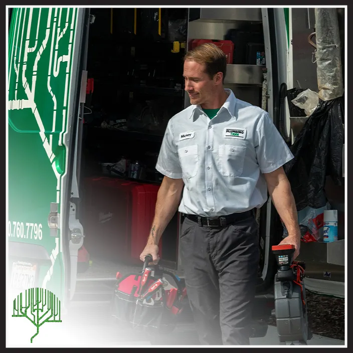 A technician in a company uniform carries equipment from a service van with tools and supplies inside.