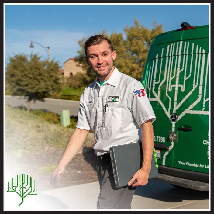 A plumber in uniform holding a folder walks toward the camera, with a green company van and trees in the background.